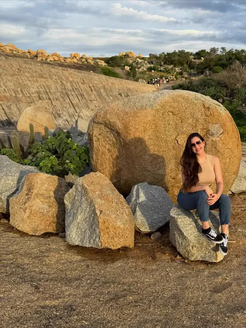 Raissa sentada nas pedras do Lajedo do Pai Mateus, em Cabaceiras